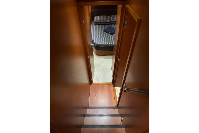 Slide: The Image of Interior view of 2015 Beneteau Swift Trawler 50 cabin with wooden stairs and cozy bed. - 69