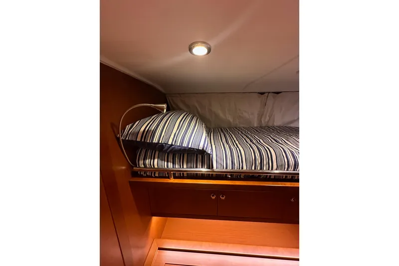 Slide: The Image of Cozy cabin bed in 2015 Beneteau Swift Trawler 50 with striped bedding. - 75