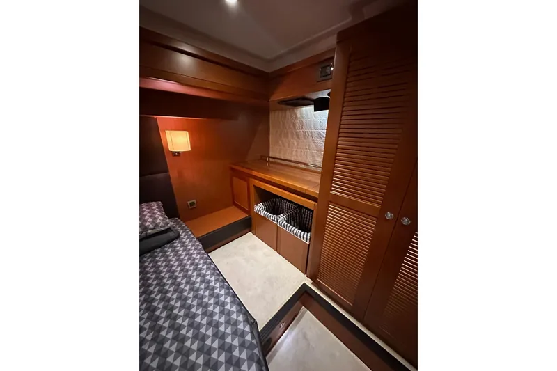 Slide: The Image of 2015 Beneteau Swift Trawler 50 cabin interior with wood finish and cozy lighting. - 79