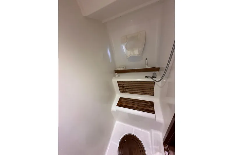 Slide: The Image of 2015 Beneteau Swift Trawler 50 bathroom with wooden accents and showerhead. - 83