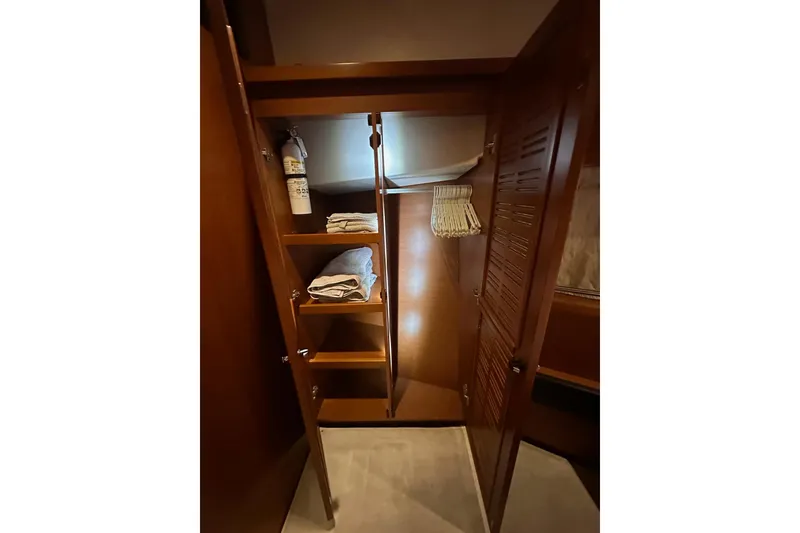 Slide: The Image of 2015 Beneteau Swift Trawler 50 interior closet with shelves and fire extinguisher. - 89