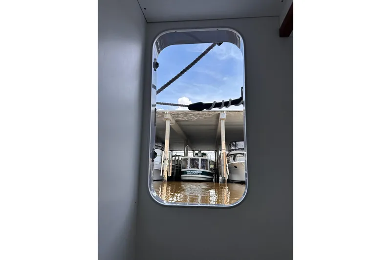 Slide: The Image of View from Beneteau Swift Trawler 50, 2015, showing marina and boats through window. - 93