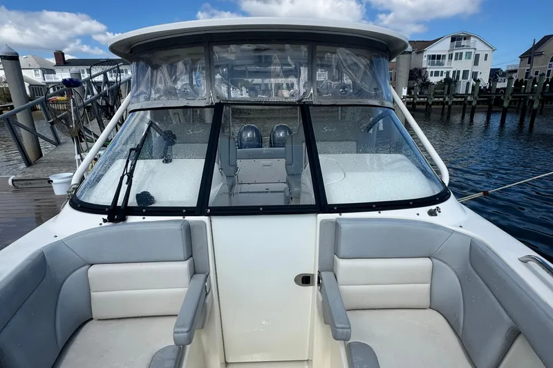 Slide: The Image of 2020 Scout 255 Dorado boat with seating, docked by waterfront homes. - 10