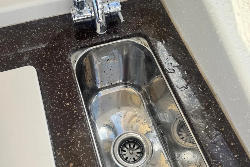 Slide: The Image of Stainless steel sink on 2020 Scout 255 Dorado boat with dark speckled countertop. - 14