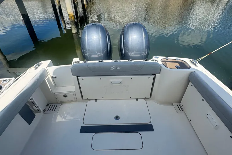 Slide: The Image of 2020 Scout 255 Dorado boat interior with twin engines, docked on calm water. - 8