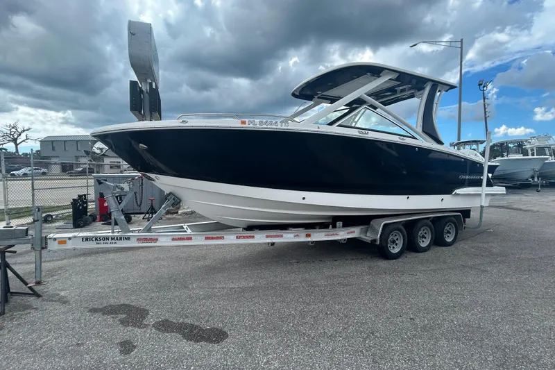 The Image of 2021 Chaparral 280 OSX boat on trailer, parked outdoors under cloudy sky. - 1