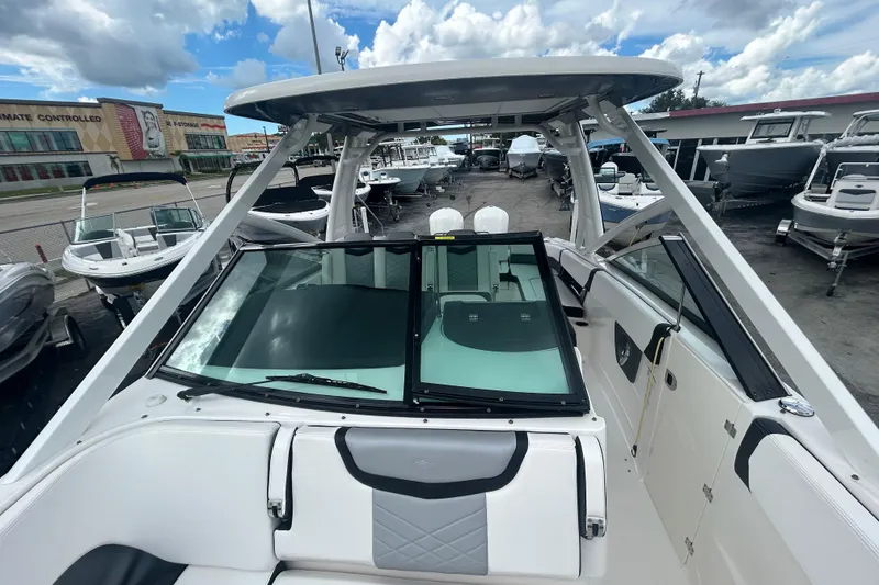 Slide: The Image of 2021 Chaparral 280 OSX boat with sleek design, docked under cloudy skies. - 17