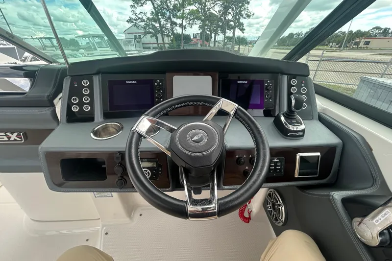 Slide: The Image of 2021 Chaparral 280 OSX boat dashboard with steering wheel and navigation controls. - 21