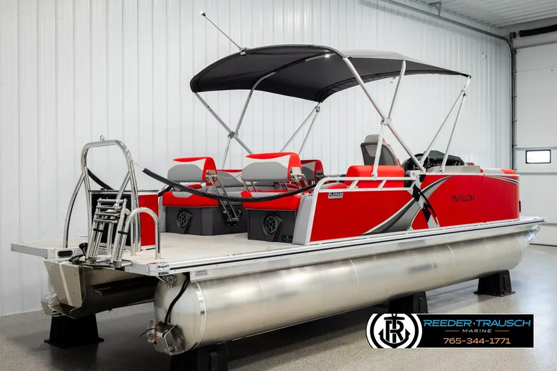 Slide: The Image of 2026 Avalon LSZ QLS pontoon boat in a showroom, featuring a sleek red design. - 6