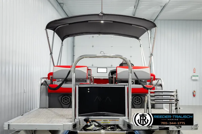 Slide: The Image of 2026 Avalon LSZ QLS pontoon boat with red seating in a storage facility. - 7