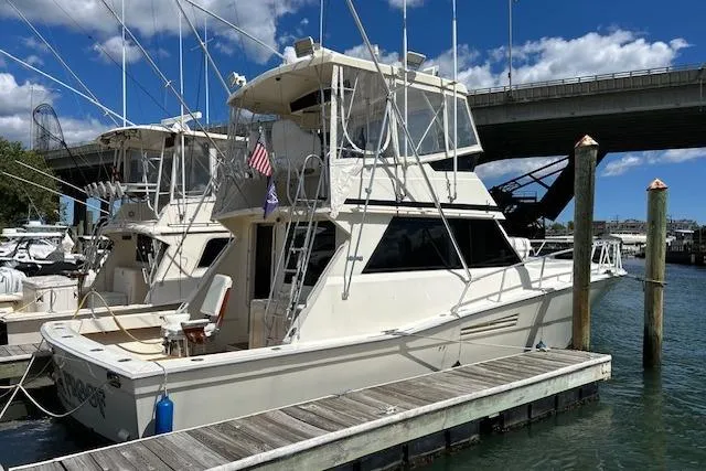 The Image of 1989 Viking 41 Convertible yacht docked at marina under blue sky. - 0