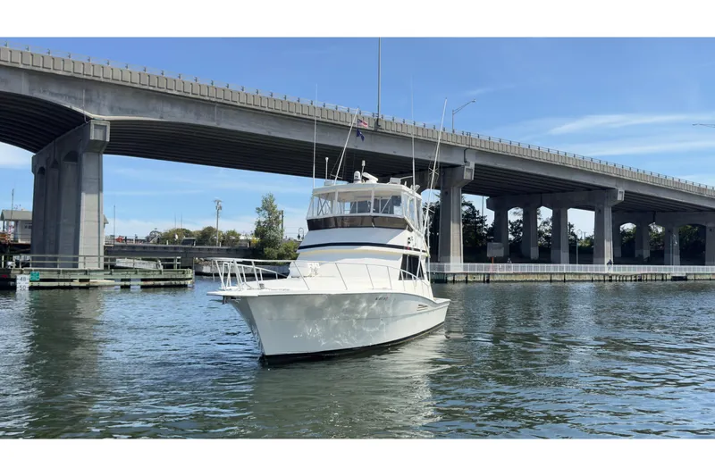 Slide: The Image of 1989 Viking 41 Convertible yacht on water near a large bridge. - 11
