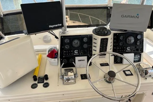 Slide: The Image of 1989 Viking 41 Convertible boat helm with Raymarine and Garmin navigation systems. - 2