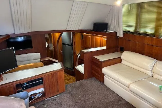 Slide: The Image of 1989 Viking 41 Convertible yacht interior with wood paneling, beige seating, and modern appliances. - 3