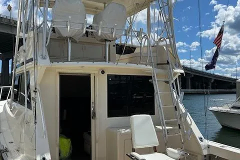 Slide: The Image of 1989 Viking 41 Convertible yacht docked under a blue sky near a bridge. - 4