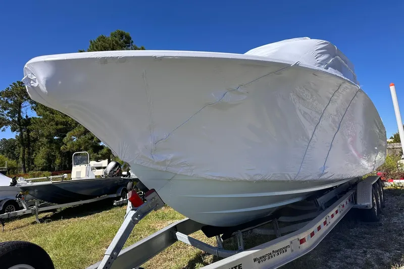 Slide: The Image of 2026 Sportsman Heritage 321 Center Console boat covered on trailer, outdoors. - 12