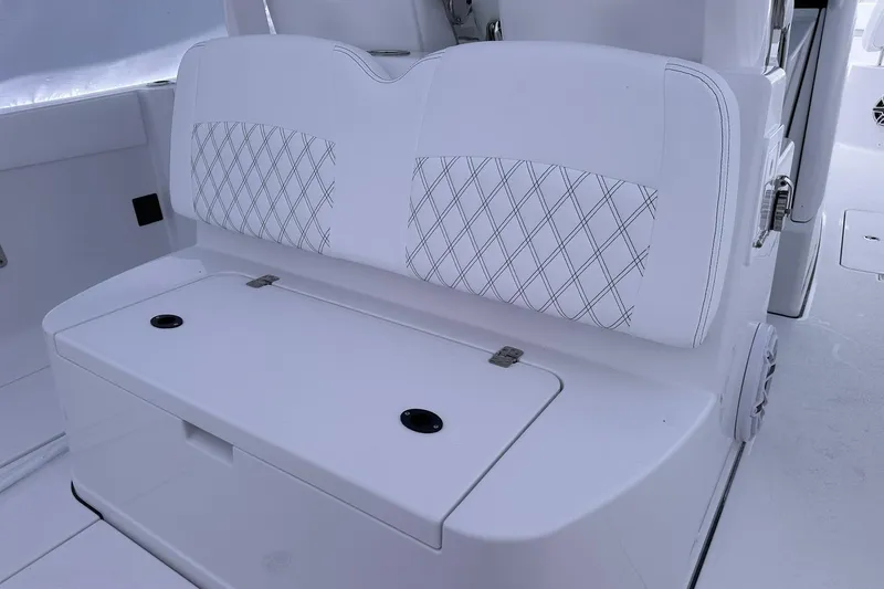 Slide: The Image of 2026 Sportsman Heritage 321 Center Console boat with white cushioned seating and storage. - 14