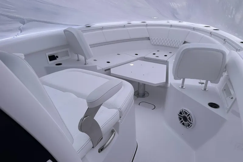 Slide: The Image of 2026 Sportsman Heritage 321 Center Console boat interior with white seating and table. - 26