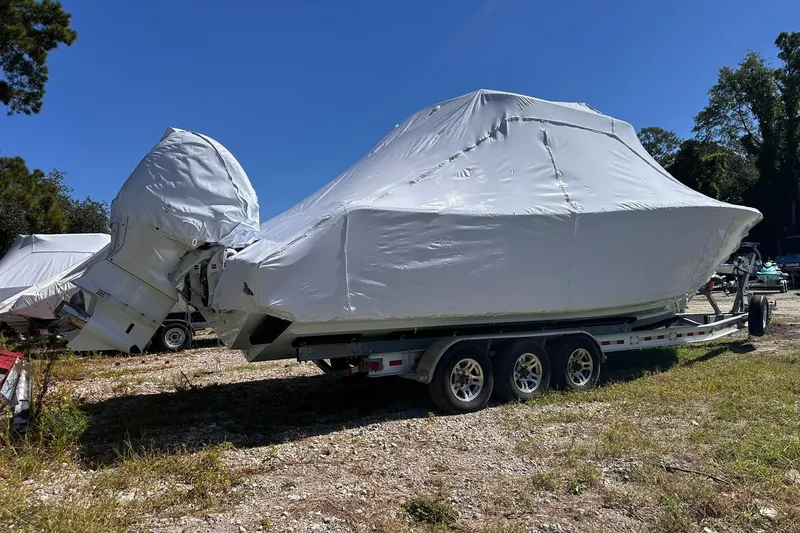 Slide: The Image of 2026 Sportsman Heritage 321 Center Console boat covered on a trailer outdoors. - 3