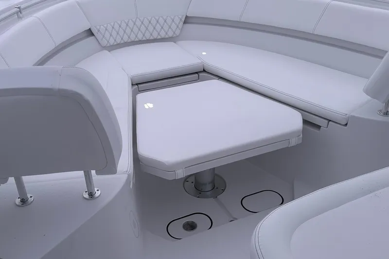 Slide: The Image of 2026 Sportsman Heritage 321 Center Console boat interior with cushioned seating and table. - 46