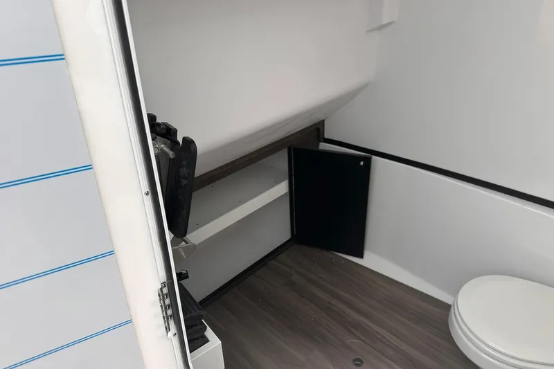 Slide: The Image of Interior of 2026 Sportsman Heritage 321 Center Console boat, featuring a compact bathroom. - 62