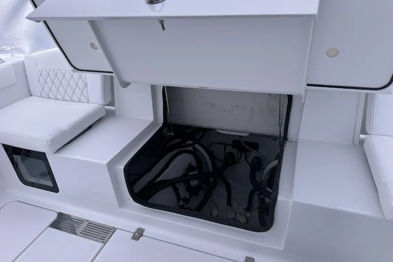 Slide: The Image of 2026 Sportsman Heritage 321 Center Console boat storage compartment with open hatch. - 68