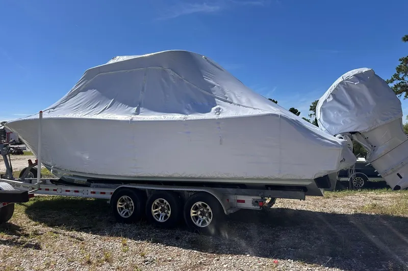 Slide: The Image of 2026 Sportsman Heritage 321 Center Console boat covered on trailer, outdoors. - 9