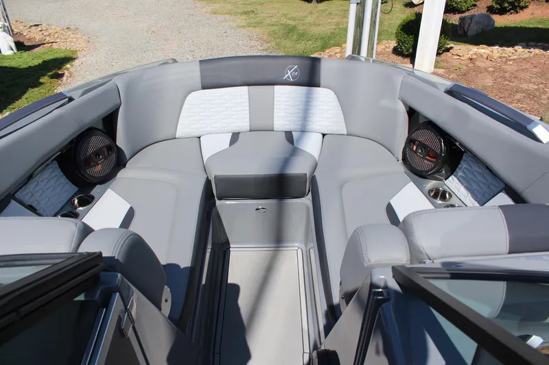 Slide: The Image of 2023 MasterCraft X24 boat interior with gray seating and built-in speakers. - 14