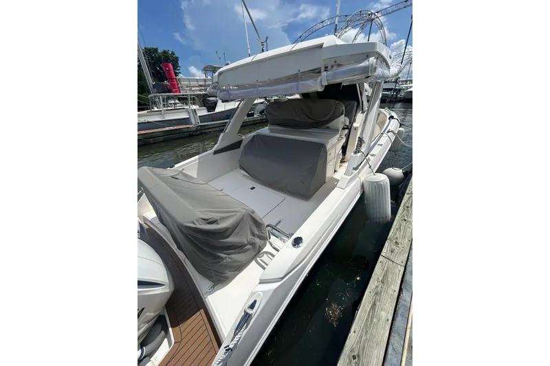 Slide: The Image of 2021 Tiara Yachts 34 LS docked, featuring covered seating and sleek design. - 15