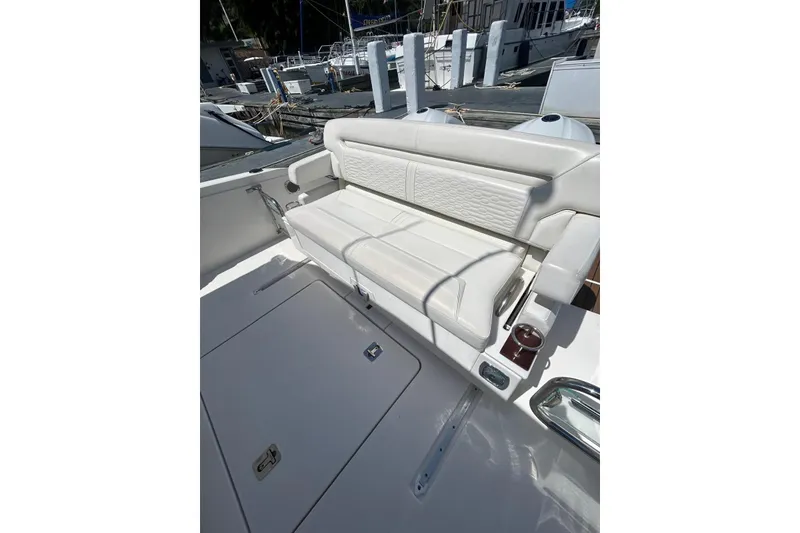 Slide: The Image of 2021 Tiara Yachts 34 LS with luxurious white seating at the dock. - 3