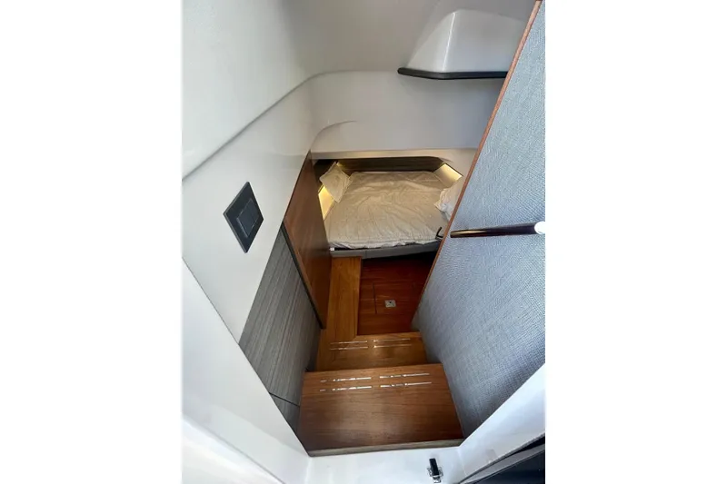 Slide: The Image of 2021 Tiara Yachts 34 LS cabin interior with wooden steps and cozy bed. - 4