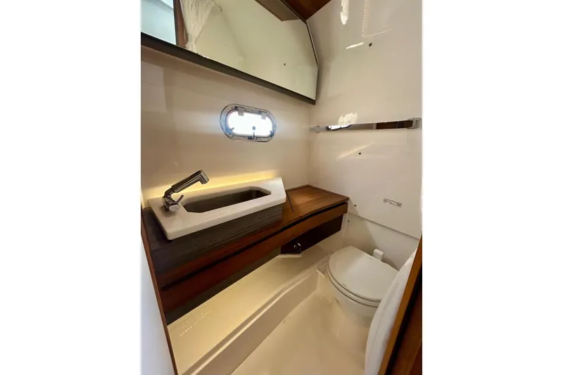 Slide: The Image of 2021 Tiara Yachts 34 LS bathroom with modern sink, toilet, and mirror. - 6
