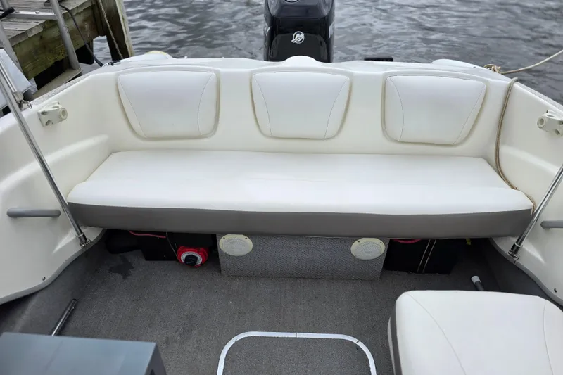 Slide: The Image of 2011 Bayliner 180 Bowrider interior with white seating and gray flooring. - 15