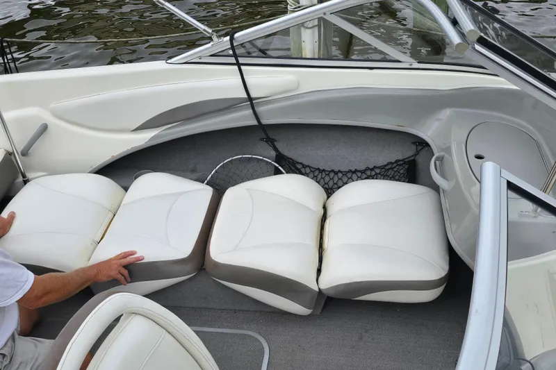 Slide: The Image of 2011 Bayliner 180 Bowrider interior with white cushioned seating and storage net. - 17