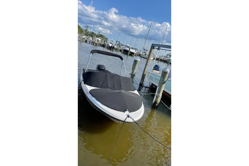 Slide: The Image of 2011 Bayliner 180 Bowrider docked at marina under clear sky. - 22
