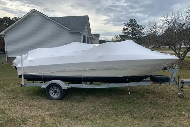 Slide: The Image of 2011 Bayliner 180 Bowrider covered on trailer, parked in residential yard. - 7