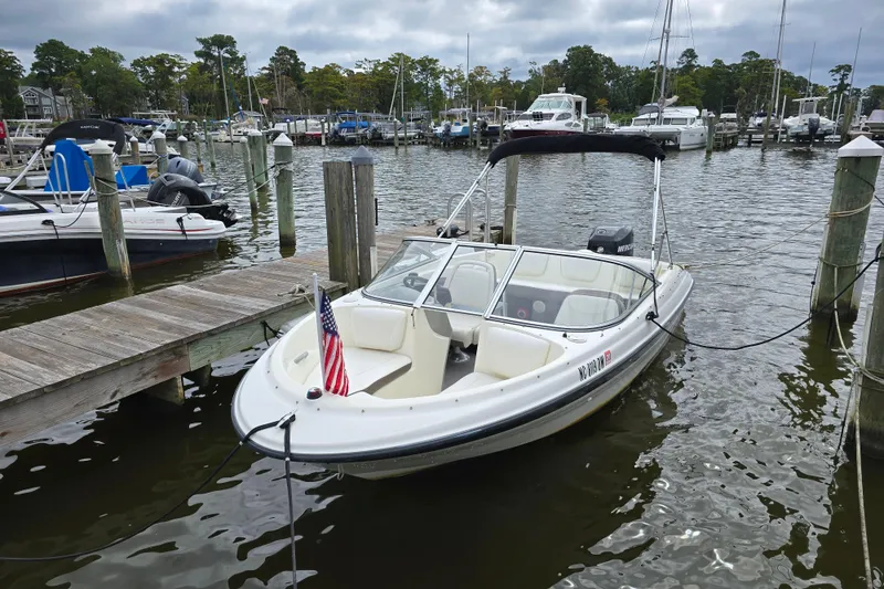 Slide: The Image of 2011 Bayliner 180 Bowrider docked at a marina with American flag. - 9