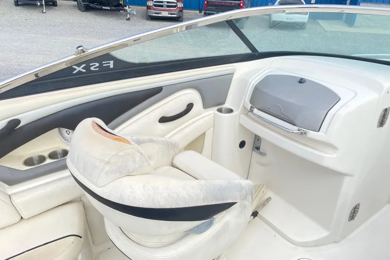 Slide: The Image of 2007 Monterey 234FSX boat interior with white seating and dashboard. - 10