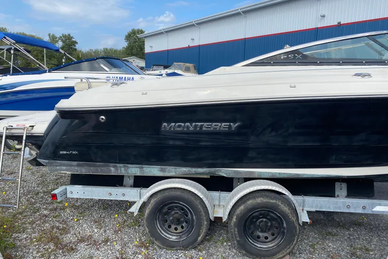 Slide: The Image of 2007 Monterey 234FSX boat on trailer, parked outdoors near other boats. - 4