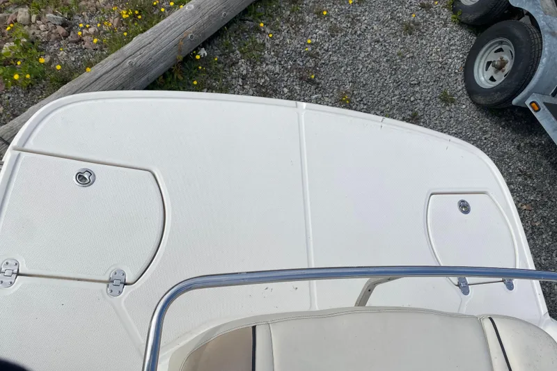 Slide: The Image of 2007 Monterey 234FSX boat deck with storage compartments and railing, on gravel surface. - 6