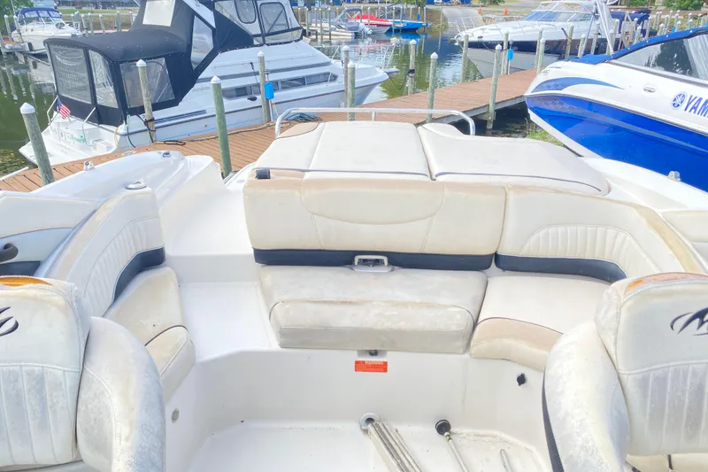 Slide: The Image of 2007 Monterey 234FSX boat interior with white seating at a marina dock. - 9