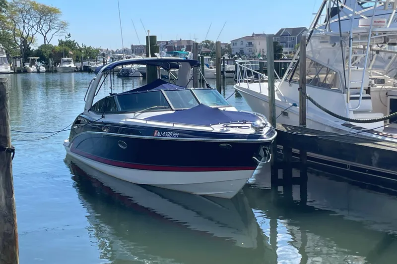 The Image of 2016 Formula 310 Bowrider docked in a marina, surrounded by other boats. - 0
