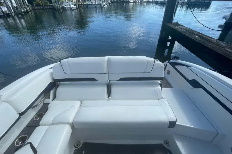 Slide: The Image of 2016 Formula 310 Bowrider boat interior with white seating at a marina. - 12