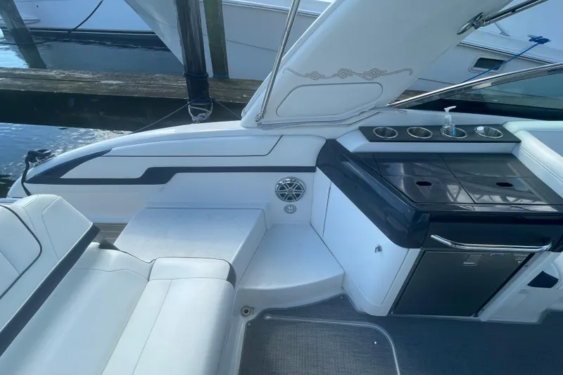 Slide: The Image of 2016 Formula 310 Bowrider interior with seating and kitchenette, docked at marina. - 18