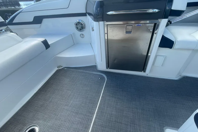 Slide: The Image of 2016 Formula 310 Bowrider interior with seating, stainless steel fridge, and carpeted flooring. - 22