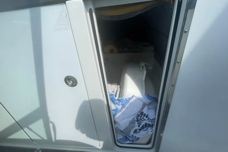 Slide: The Image of Storage compartment in a 2016 Formula 310 Bowrider boat, containing towels and equipment. - 48