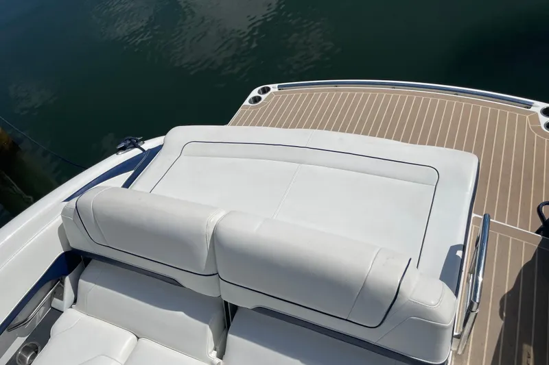 Slide: The Image of 2016 Formula 310 Bowrider boat with white seating and teak deck, docked on calm water. - 6
