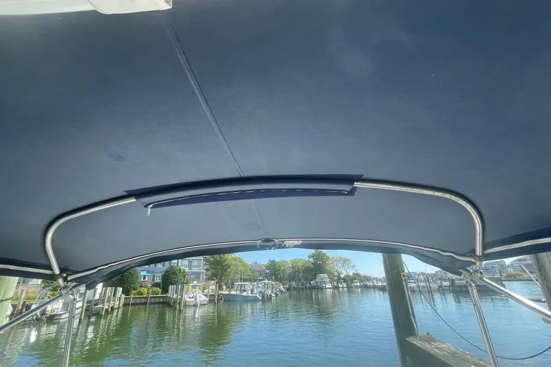 Slide: The Image of View from under the canopy of a 2016 Formula 310 Bowrider boat in a marina. - 63