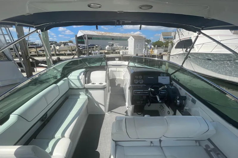 Slide: The Image of 2016 Formula 310 Bowrider boat interior with helm, seating, and marina view. - 64