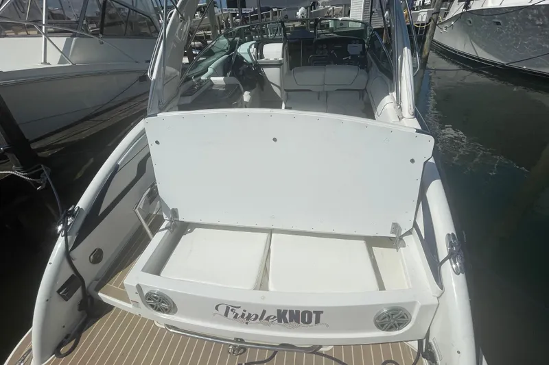 Slide: The Image of 2016 Formula 310 Bowrider boat docked, rear view with open storage compartment. - 8